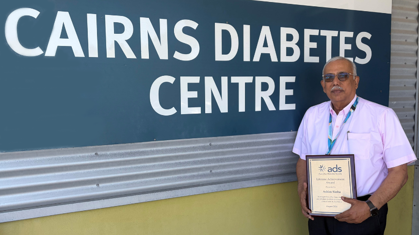 Man standing in front of a Cairns Diabetes Centre sign holding a certificate